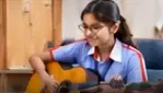 Student playing an acoustic guitar