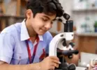 Student examining a specimen through a microscope